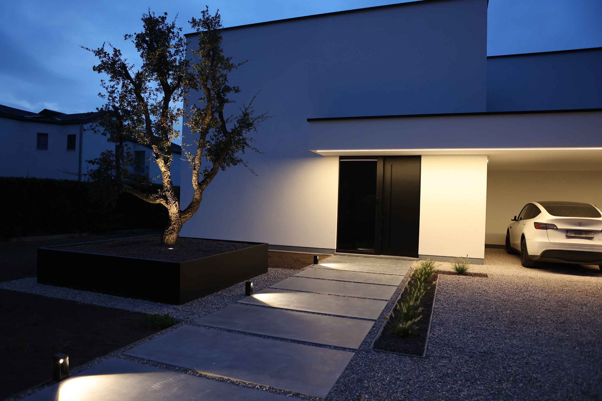 Tuin met sfeerverlichting bij avond, gerealiseerd door Hoffelijk